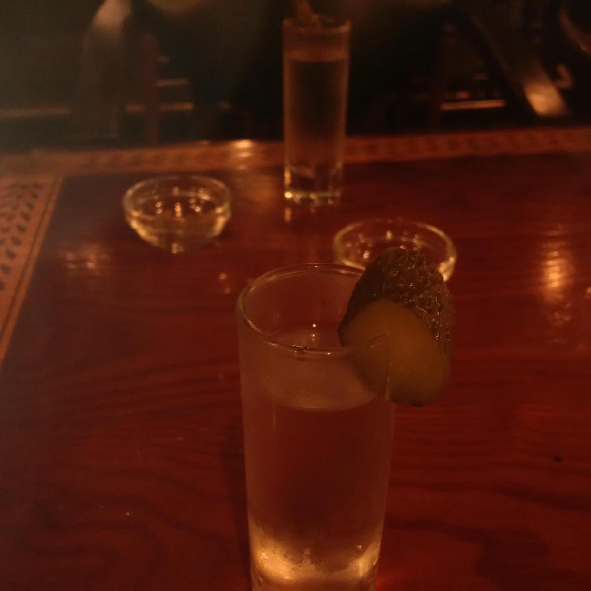 A shot of vodka with a slice of pickle