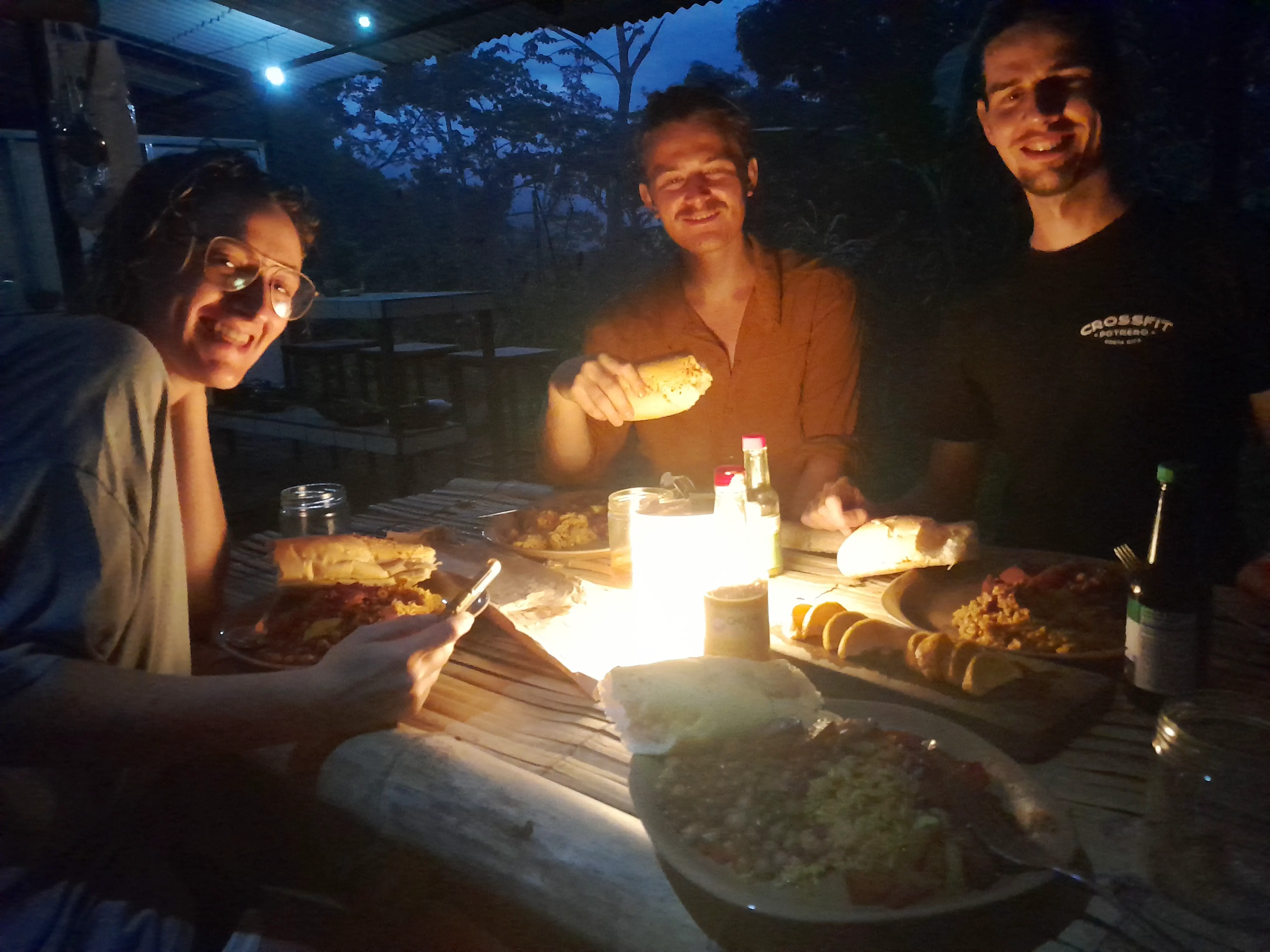 A group of people eating a meal by candlelight