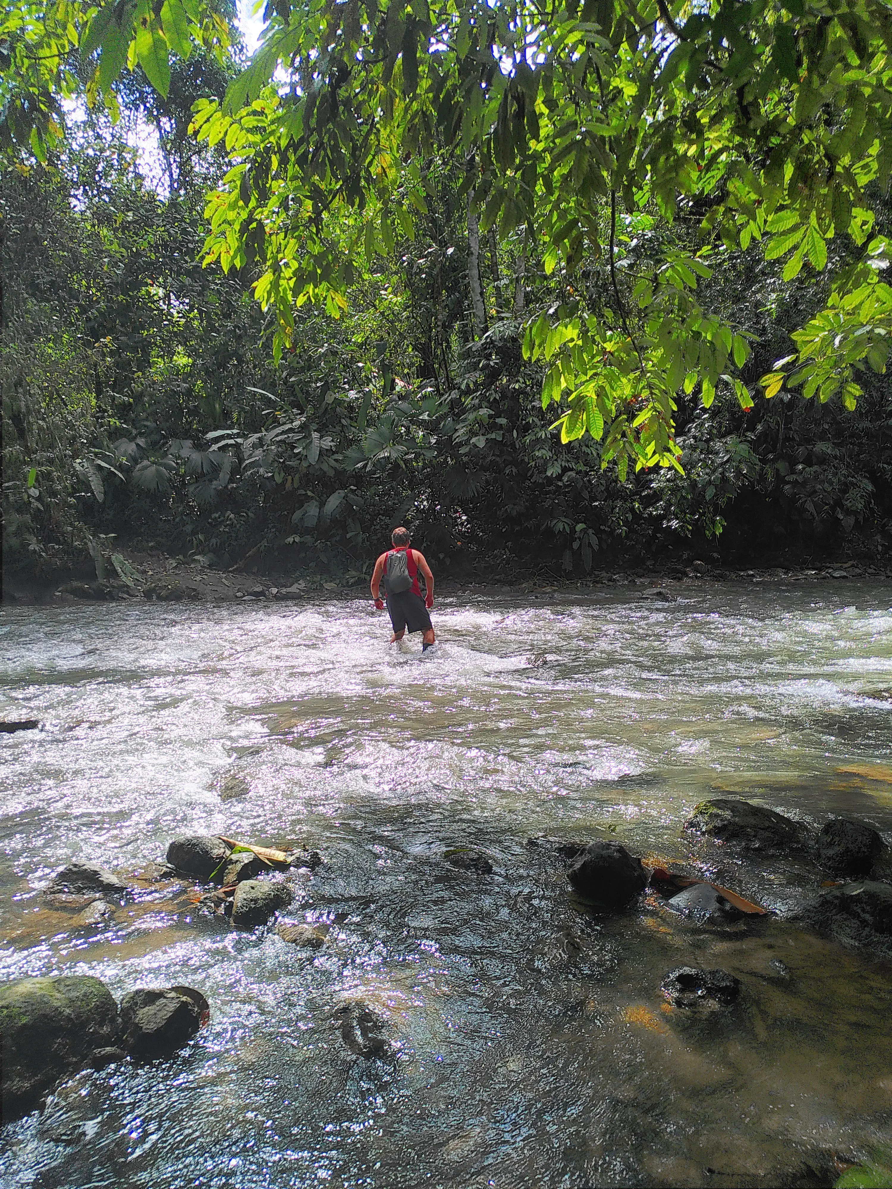 A man wading through a river, the water up to his waist