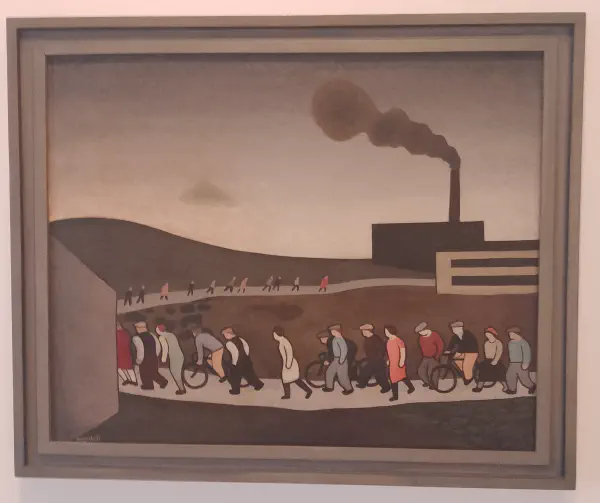 A group of workers walking and cycling towards a distant, smoke-billowing factory