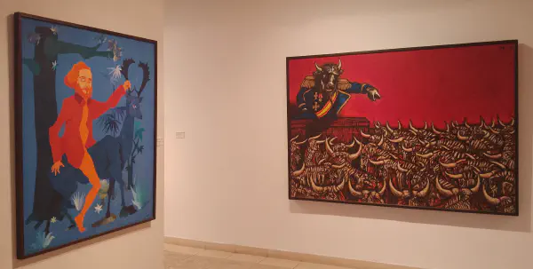 An orange man rides a blue stag through a forest at night-time