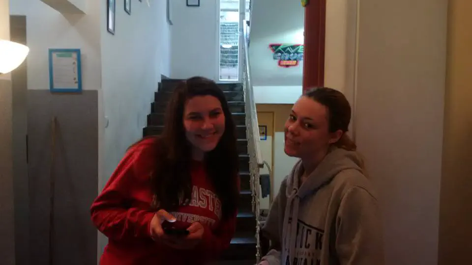 Two girls posing in a hostel staircase