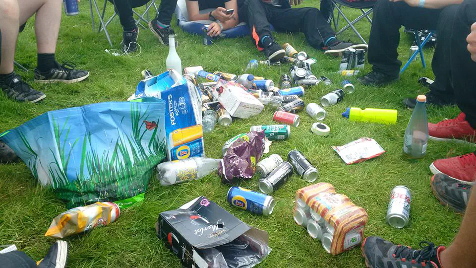 A pile of alcoholic drinks laying on grass