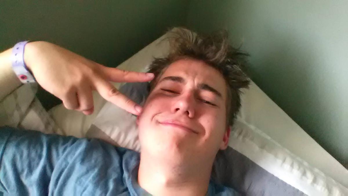 Me in my bed, giving a peace sign
