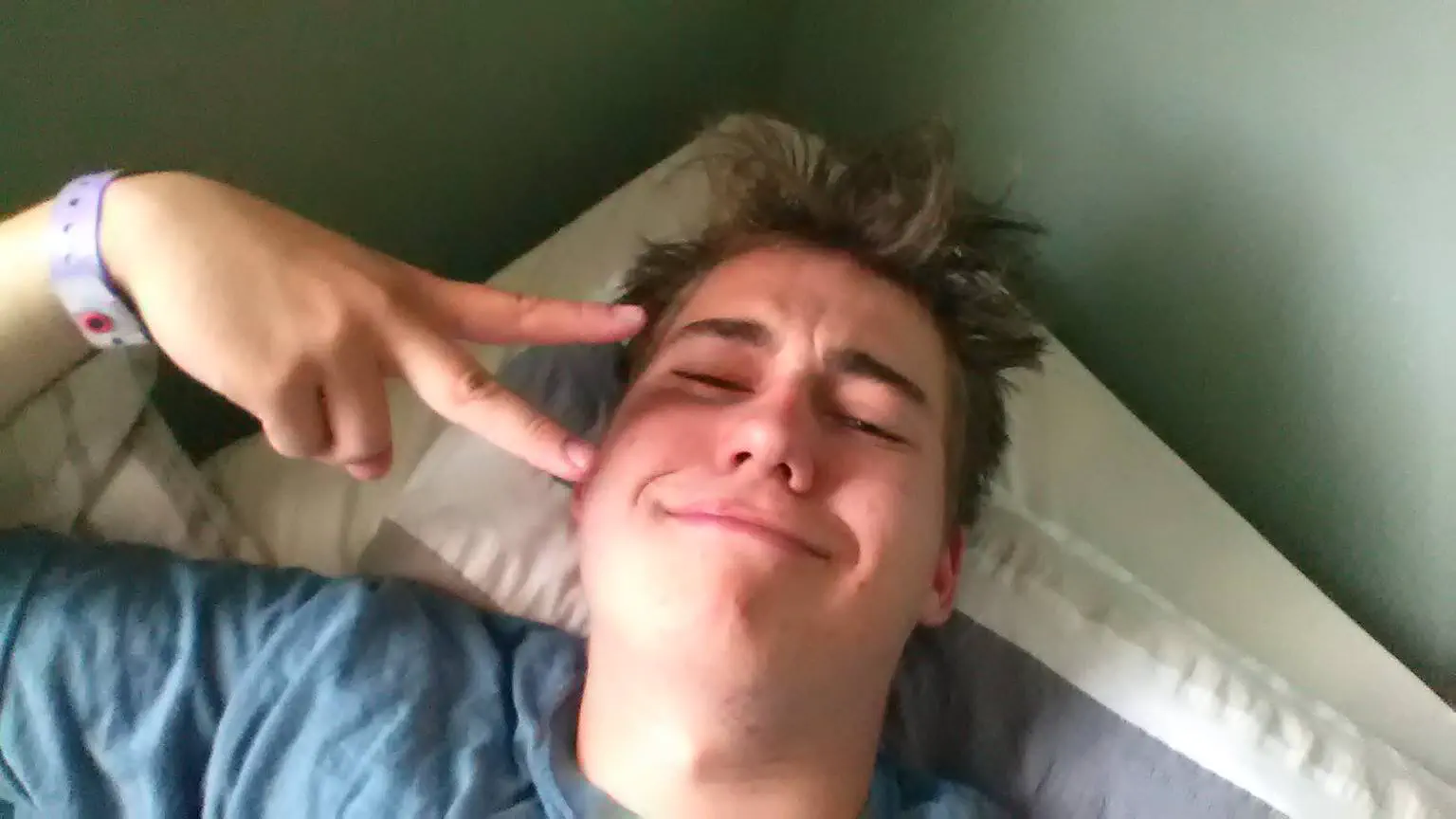 Me in my bed, giving a peace sign