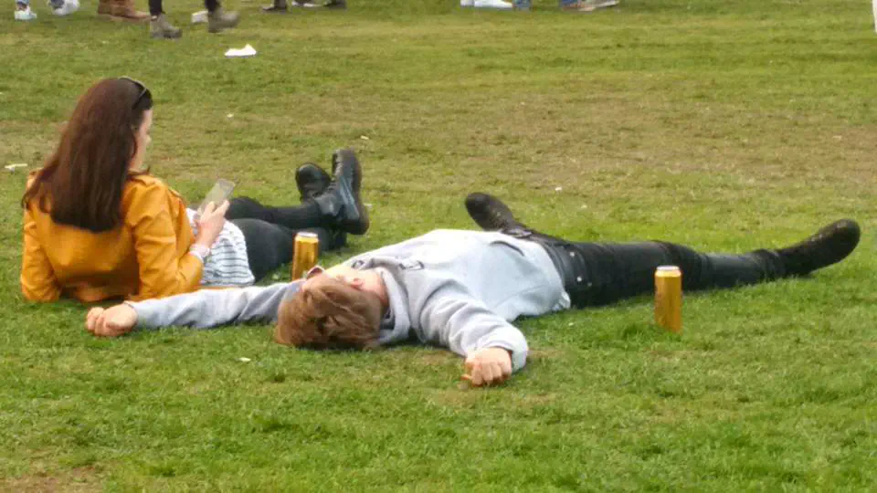 A couple laying on the grass inside the main arena