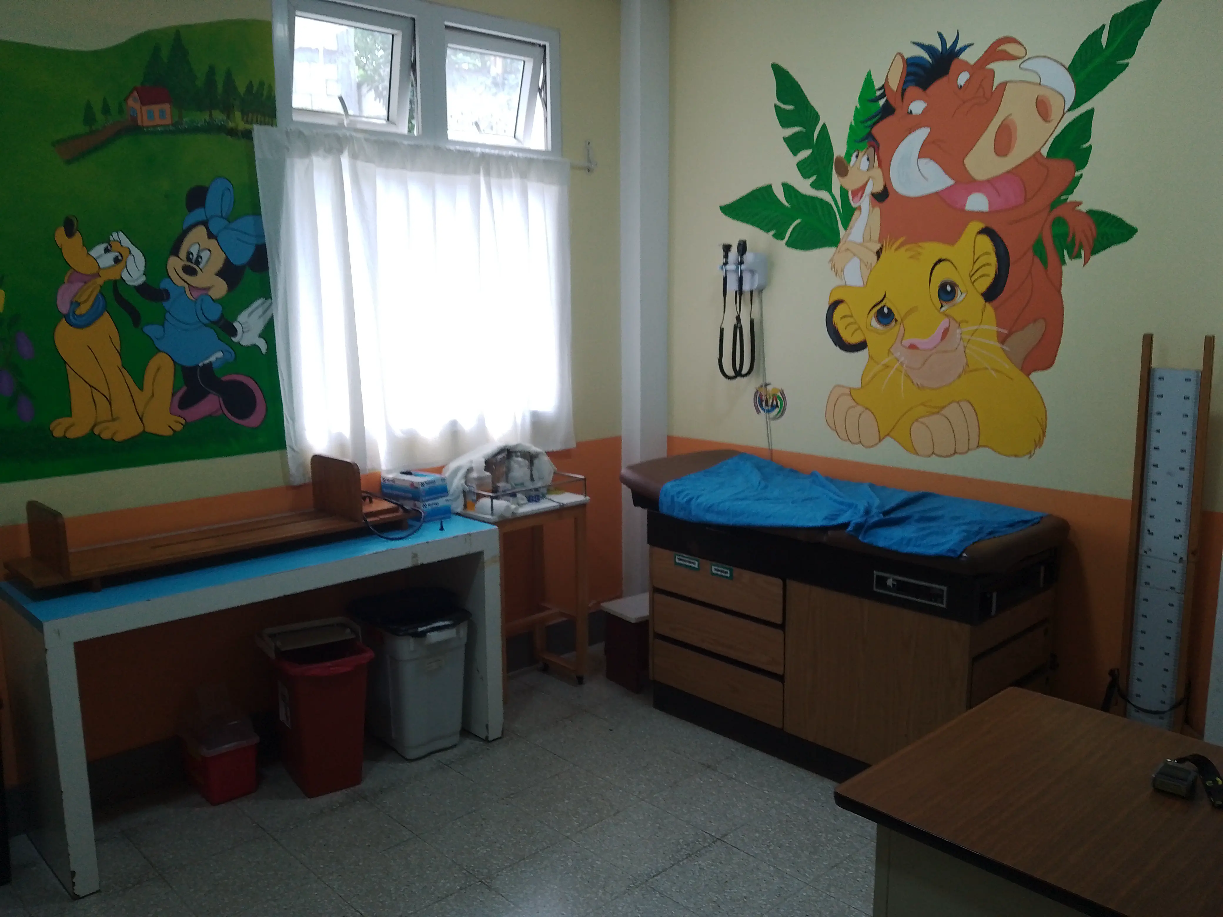 A doctor's office with paintings of cartoon animals on the walls