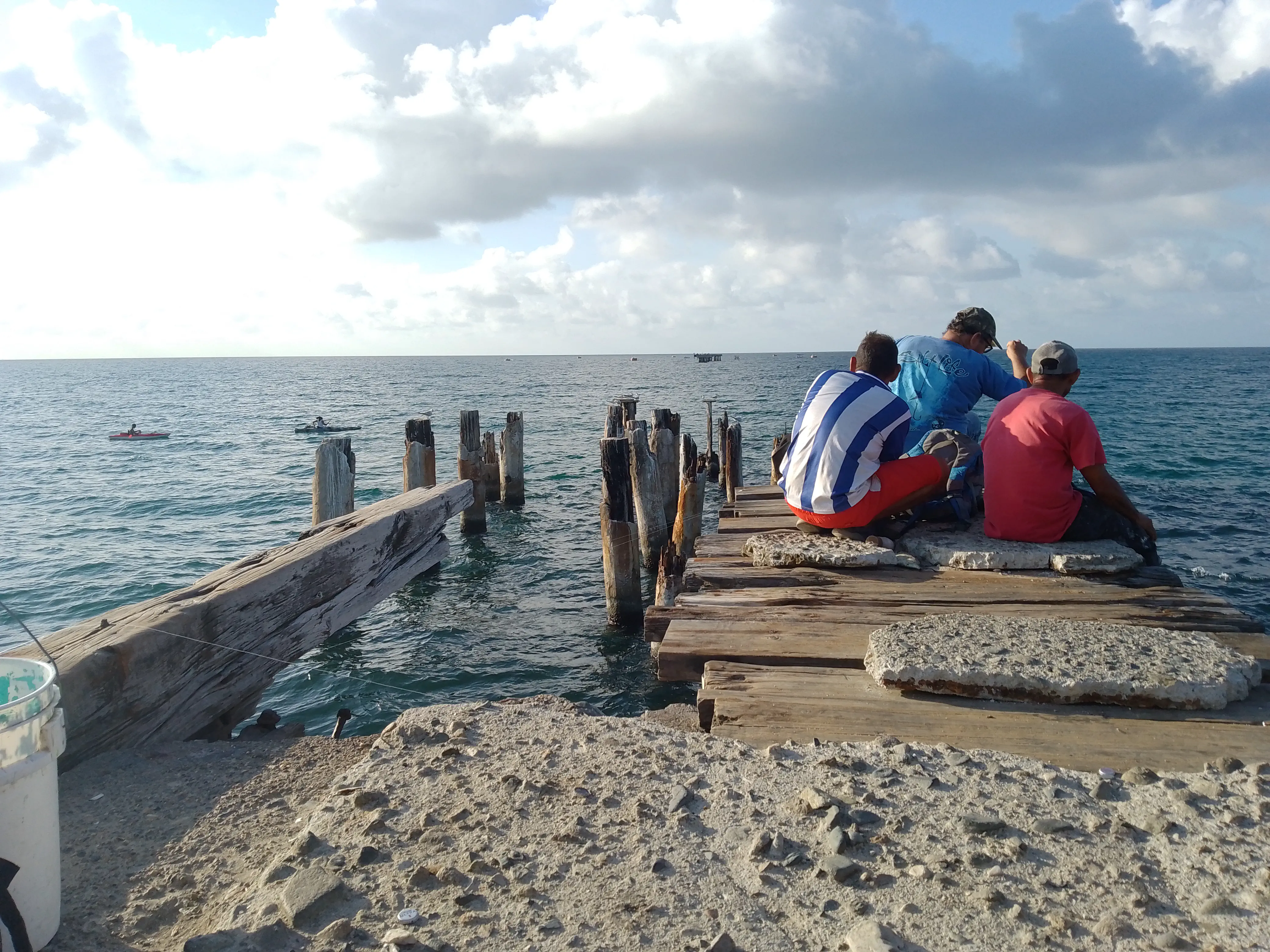Men sitting at the end of a pier