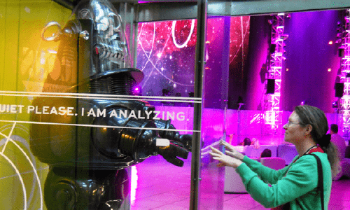 A woman reaching out to a robot