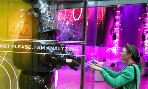 A woman reaching out to a robot