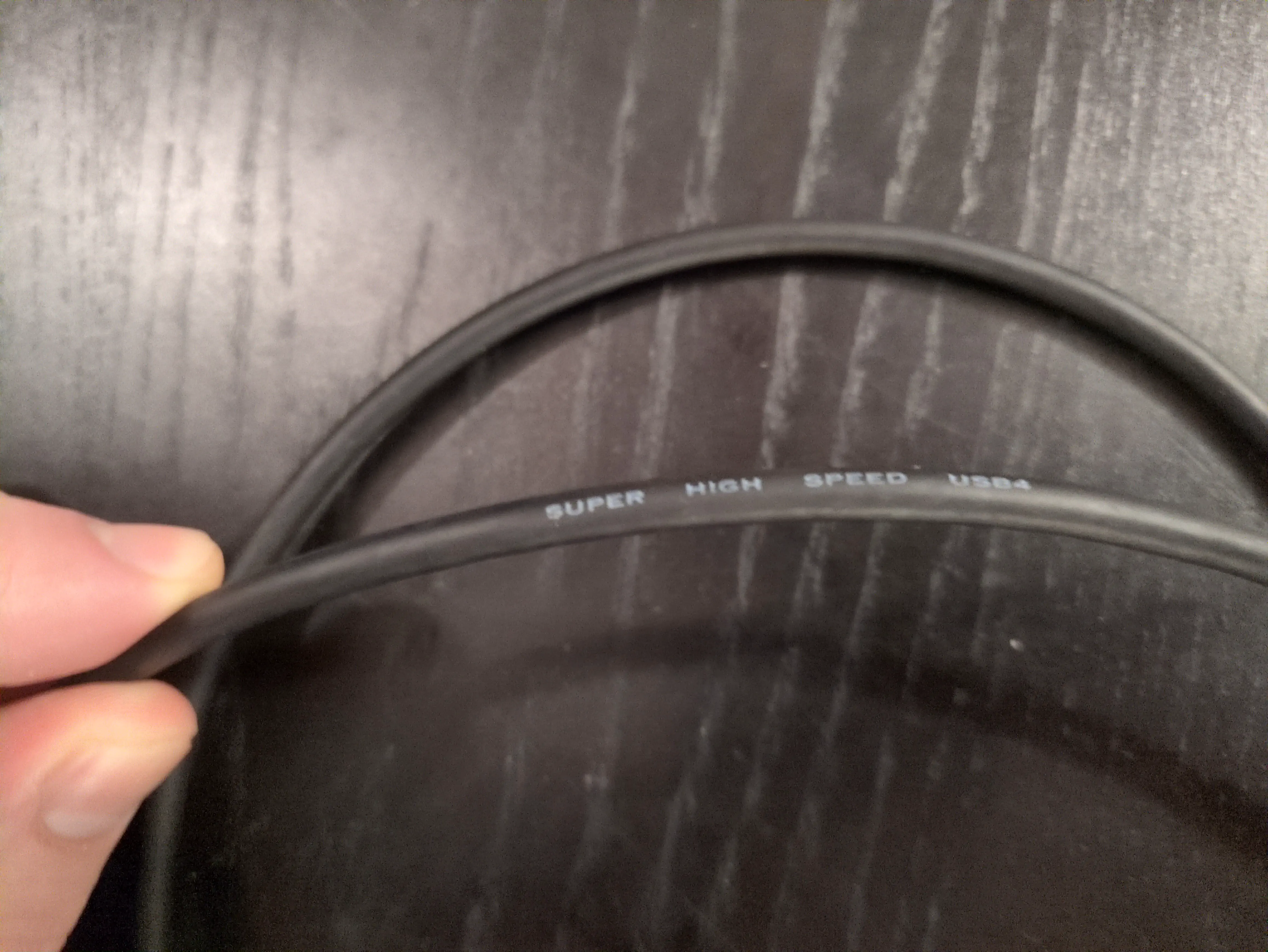 A cable reading {{< q >}}Super High Speed {{< abbr "usb" >}}4{{< /q >}}