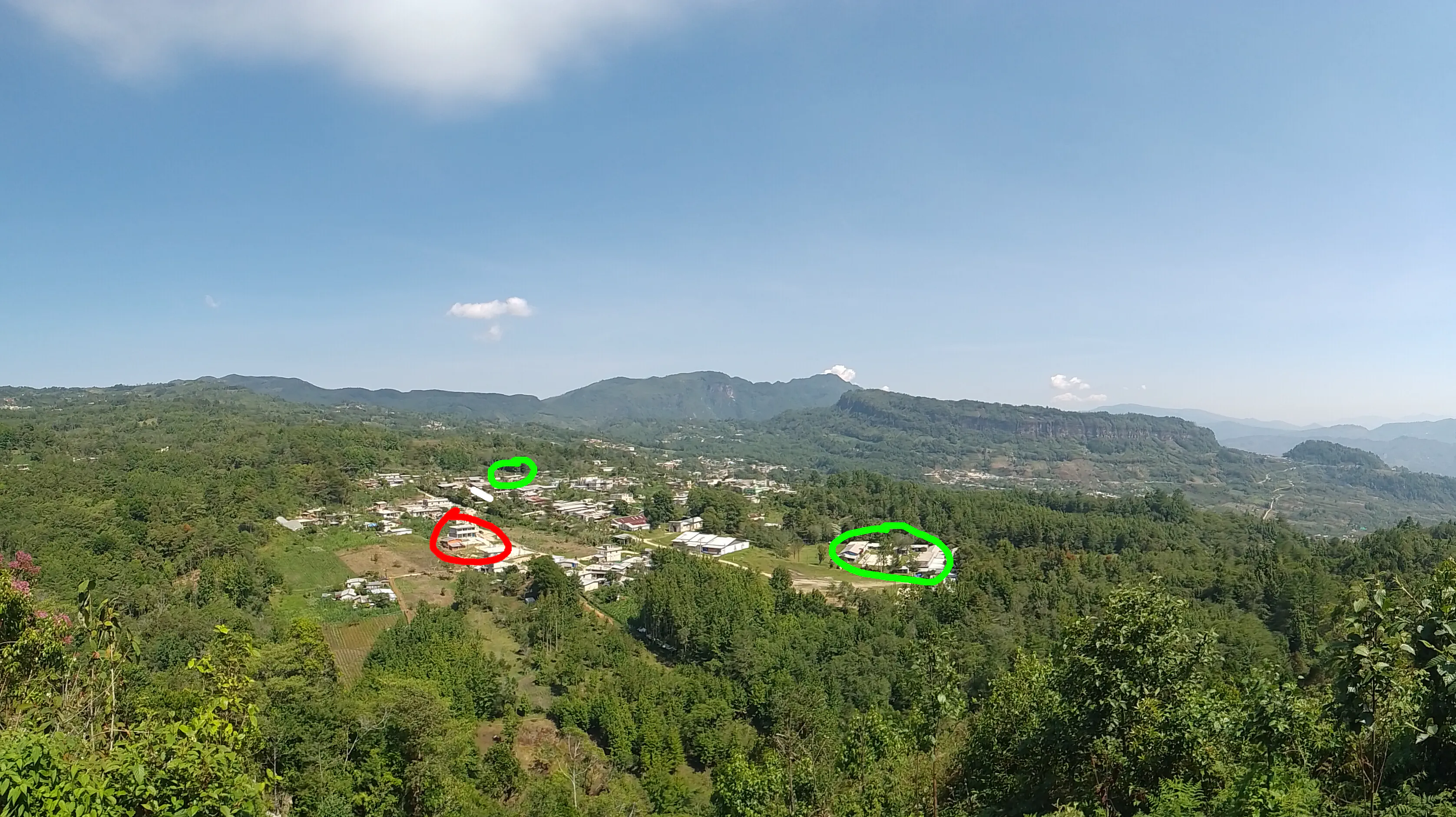 Mountain town viewed from afar, with several buildings circled