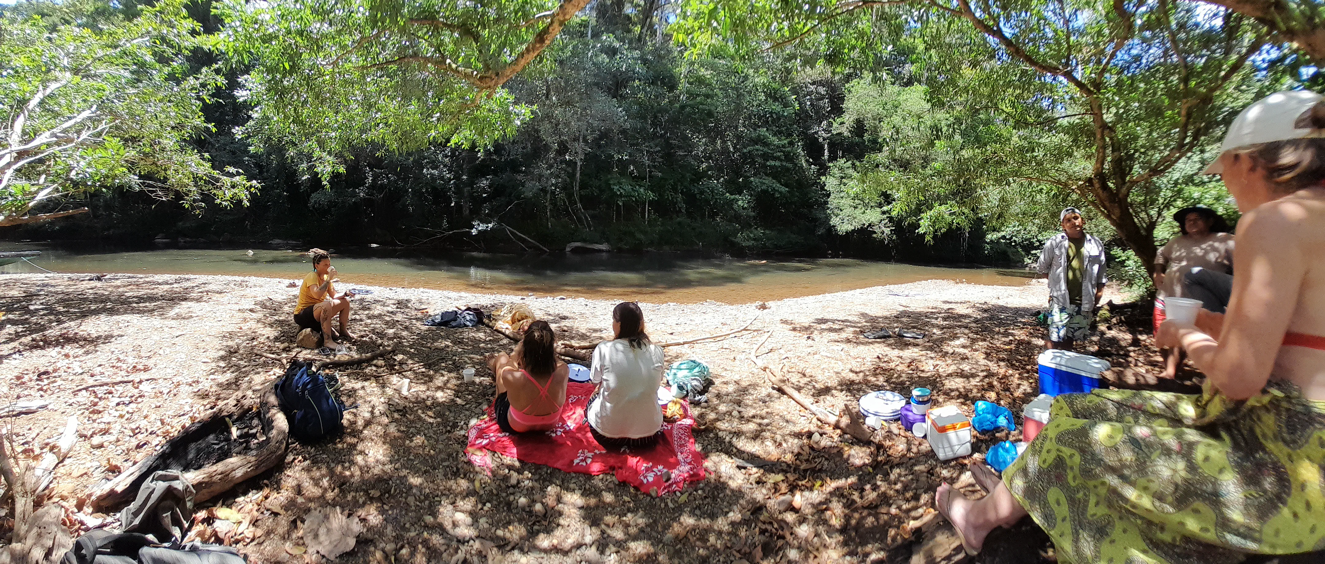 A group of people sitting beside a river