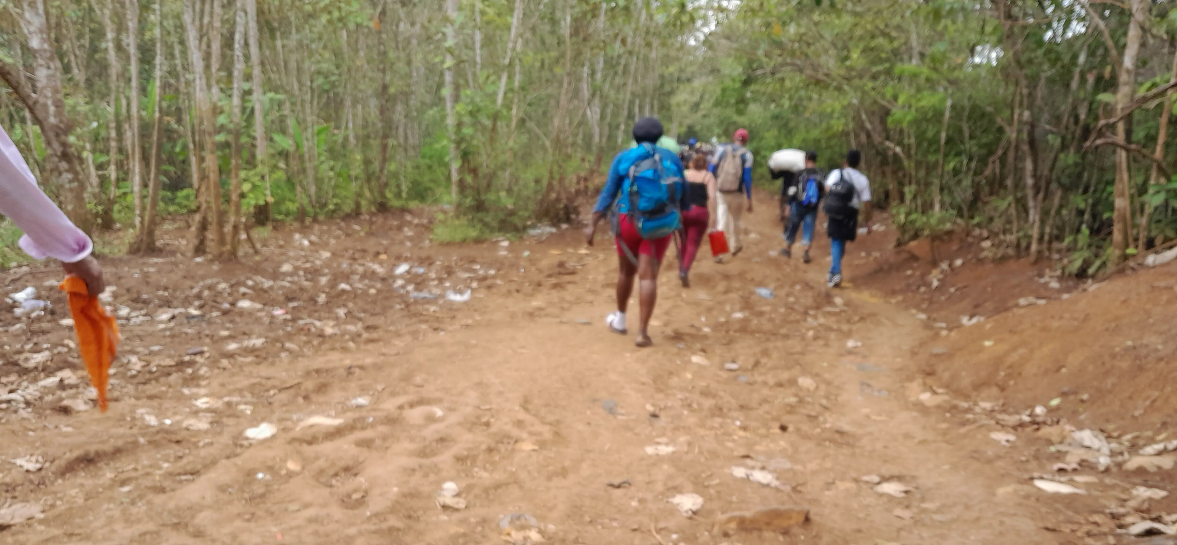 A group of people walking along a dirt track