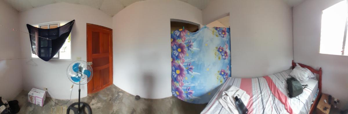 A spartan bedroom, divided from the rest of the building with a towel