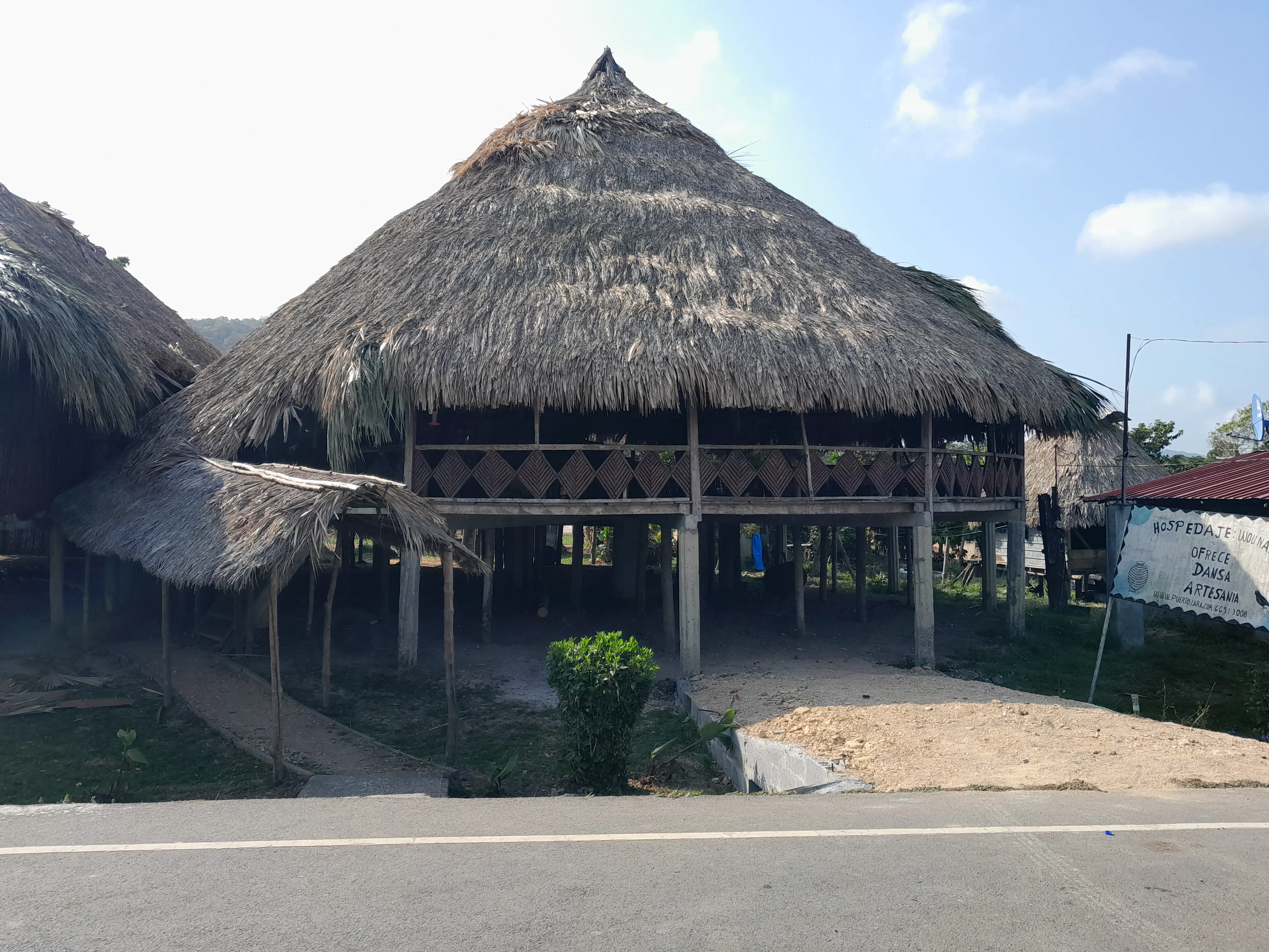 The outside of a large wooden house on stilts