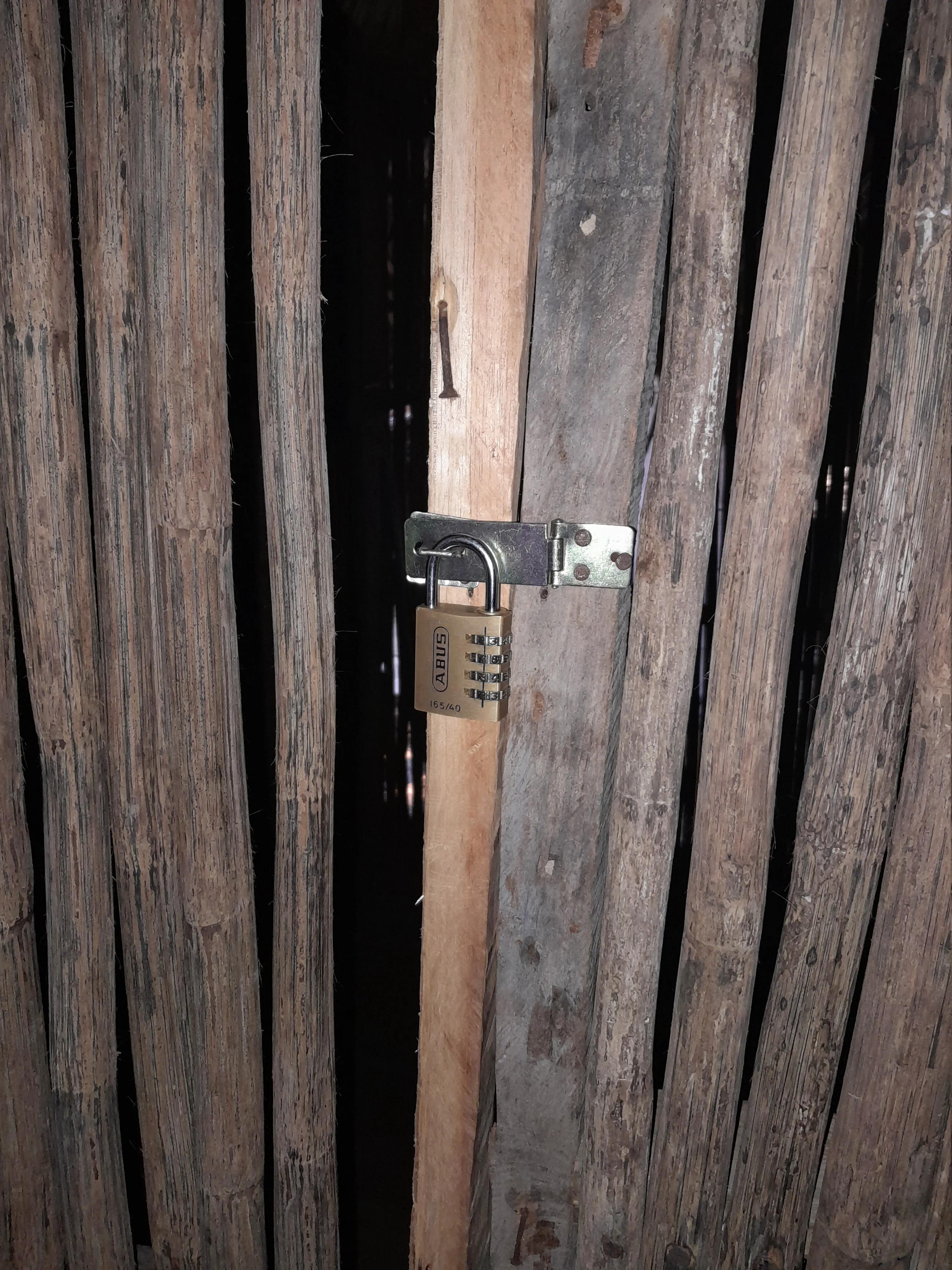 A padlock on a flimsy wooden door