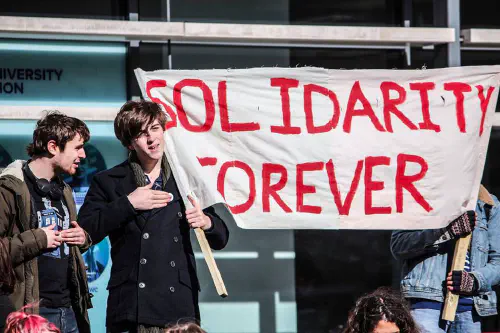 Students at a protest, holding a banner that reads 'Solidarity forever'