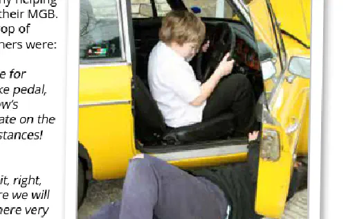 Young boy in drivers seat of car, with man laying underneath