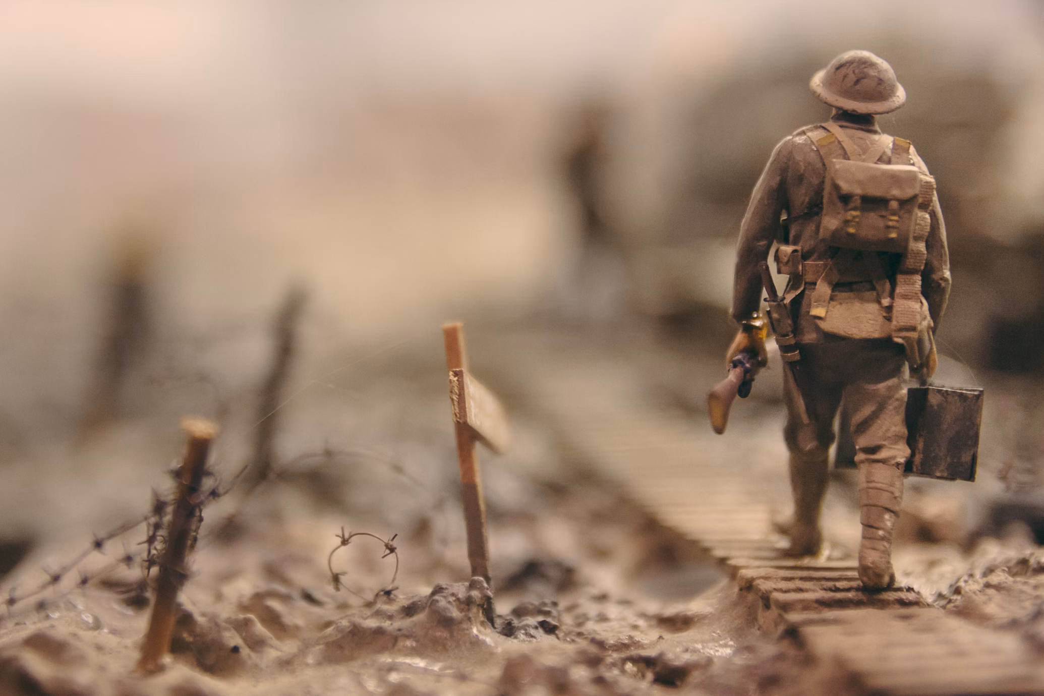 WWI soldier walking through muddy trenches