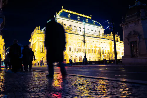 People walking in front of a building at night