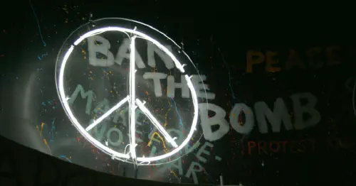CND symbol in front of graffiti reading 'Ban the bomb'