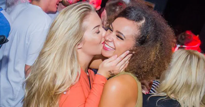 One girl kissing another on the cheek