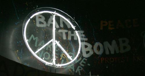 CND symbol in front of graffiti reading 'Ban the bomb'