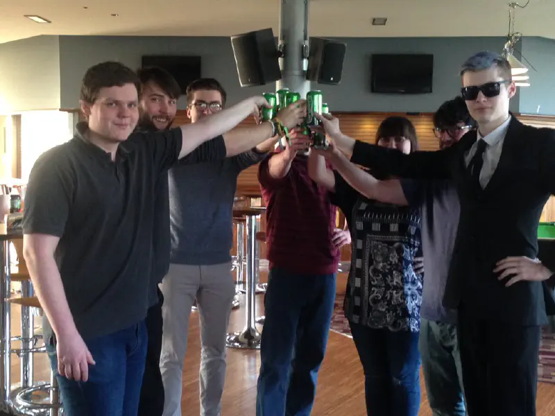 A group of students in a circle toasting towards the centre
