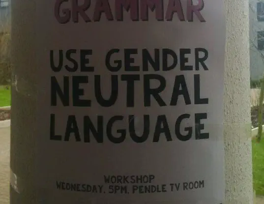 A poster on a piller that reads 'Use gender neutral language'