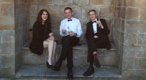 Students in formalwear drinking gin in an alcove